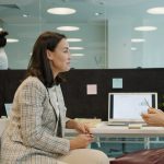 Two women talking at a desk in an office