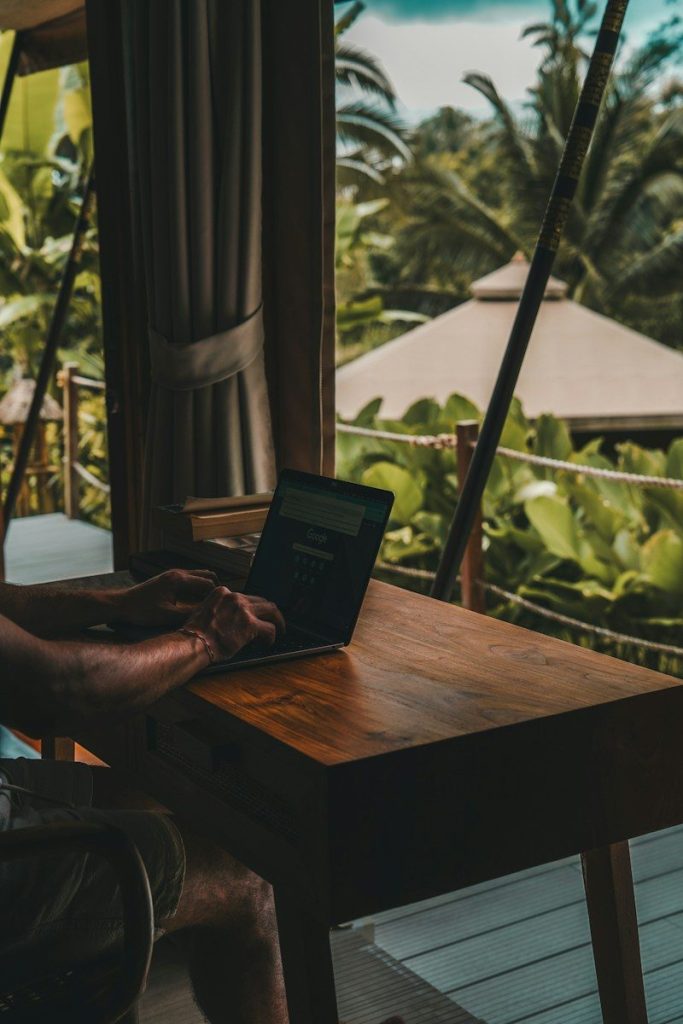 A man sitting at a table using a laptop computer