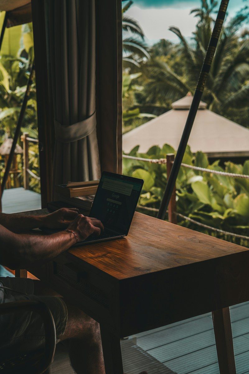 A man sitting at a table using a laptop computer